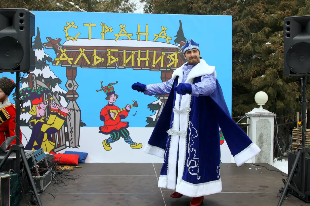 Дед Мороз в синем кафтане на сцене с вывеской «Масленица»